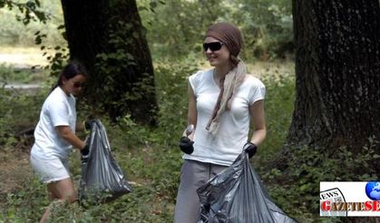 Foreigner youth campers collect garbage in front of picknickers, call on the world to recycle